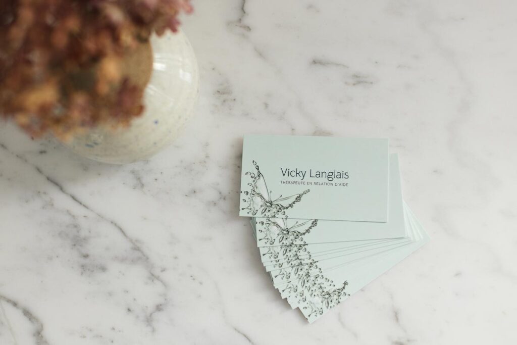 Cartes d’affaires d’une thérapeute en relation d’aide avec image d’un papillon qui prend son envol.